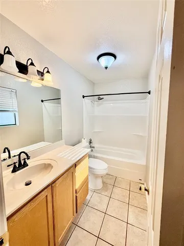 a bathroom with a granite countertop sink a toilet and shower