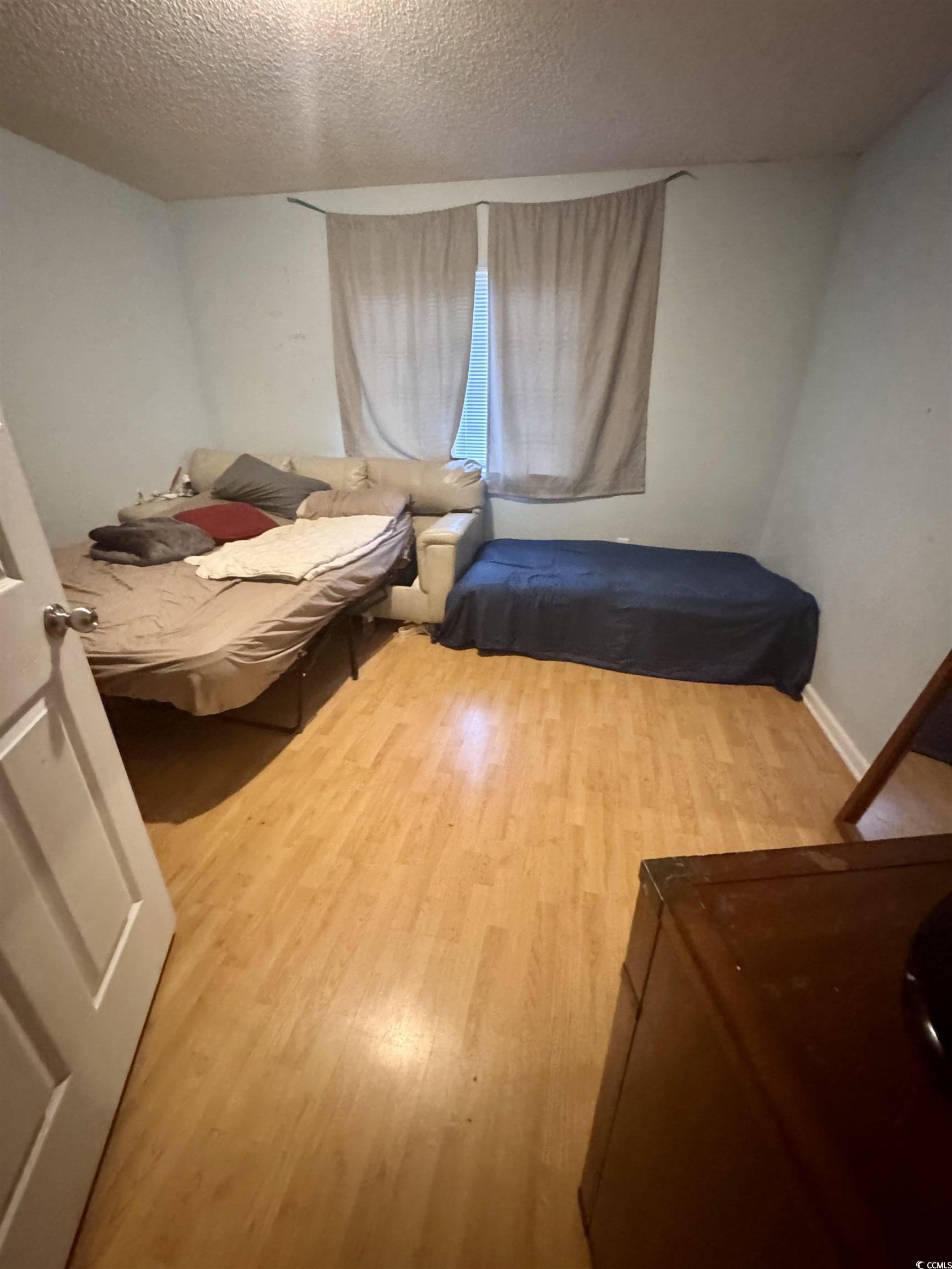 1207 Pinegrove Drive, Unit D Myrtle Beach, SC 29577 - Photo 11 of 16 Half bathroom featuring light tile patterned flooring, vanity, a textured ceiling, and stacked washer / dryer