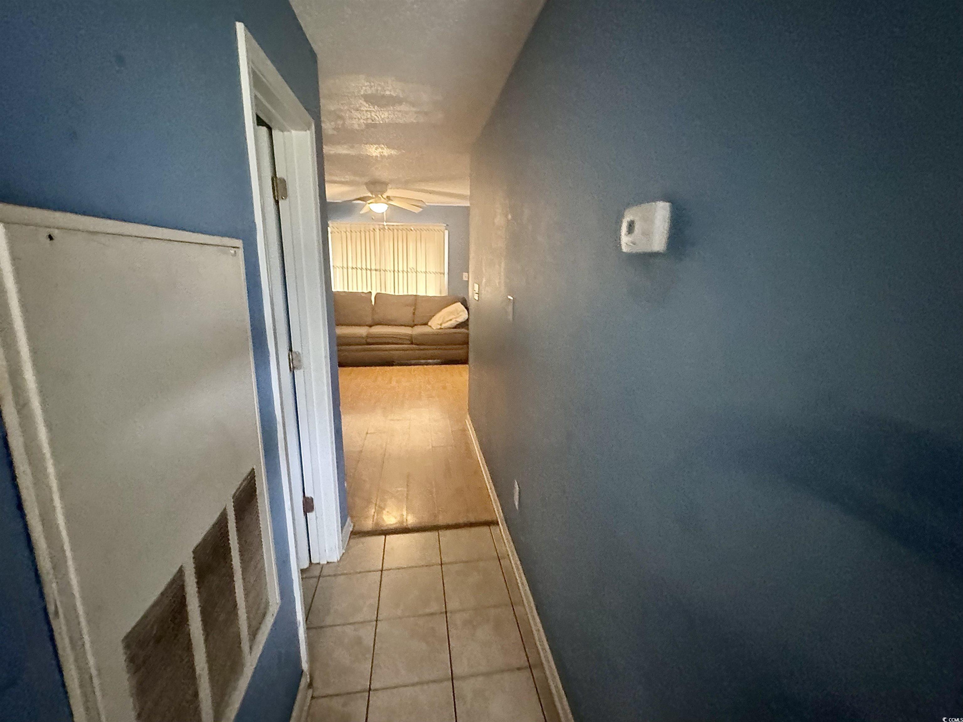 1207 Pinegrove Drive, Unit D Myrtle Beach, SC 29577 - Photo 4 of 16 Kitchen with white appliances, light tile patterned floors, brown cabinets, light countertops, and a textured ceiling