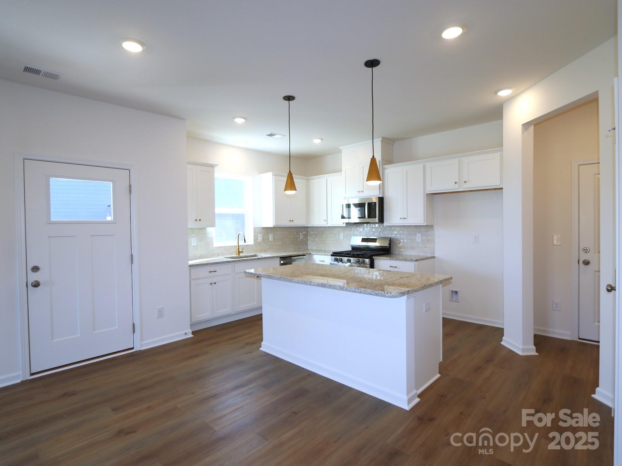 1014 Overbrook Place Wingate, NC 28174 - Photo 3 of 21 a kitchen with stainless steel appliances granite countertop a sink a stove a refrigerator and white cabinets