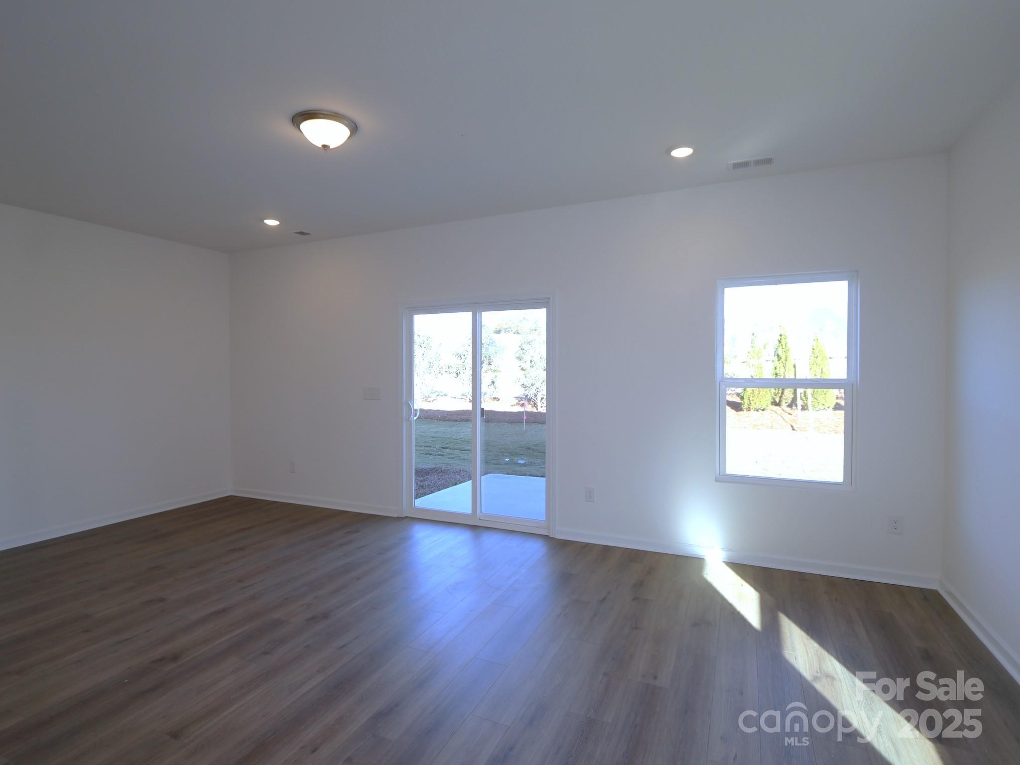 1014 Overbrook Place Wingate, NC 28174 - Photo 8 of 21 an empty room with wooden floor and windows