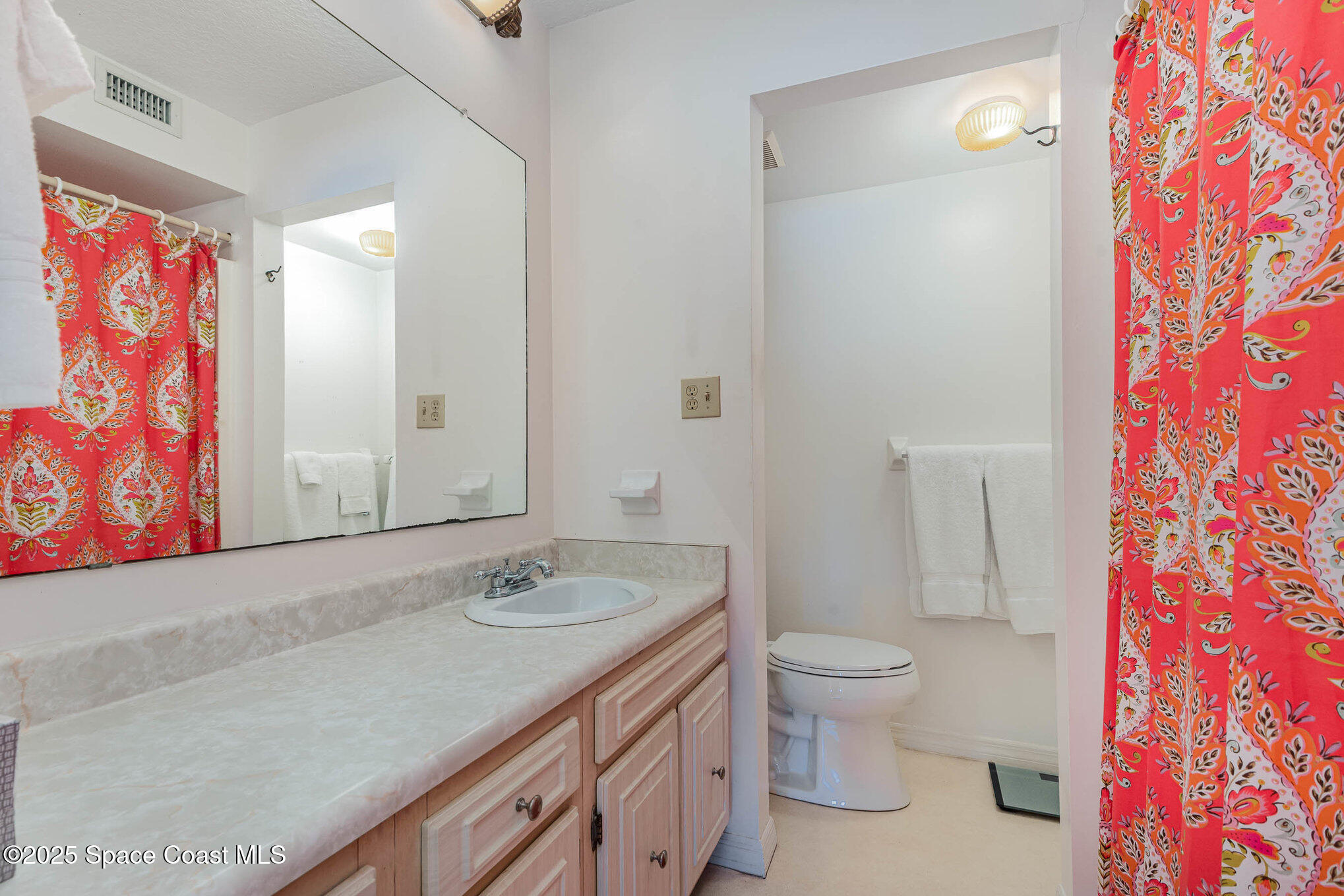 1999 South Banana River Boulevard, Unit 313 Cocoa Beach, FL 32931 - Photo 18 of 24 a bathroom with a granite countertop sink a toilet and shower curtain