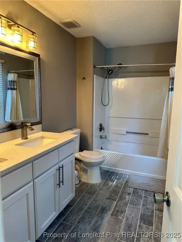 a bathroom with a granite countertop sink toilet a mirror and bathtub