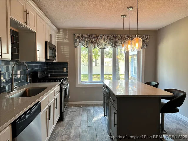 a kitchen with a sink stove and microwave