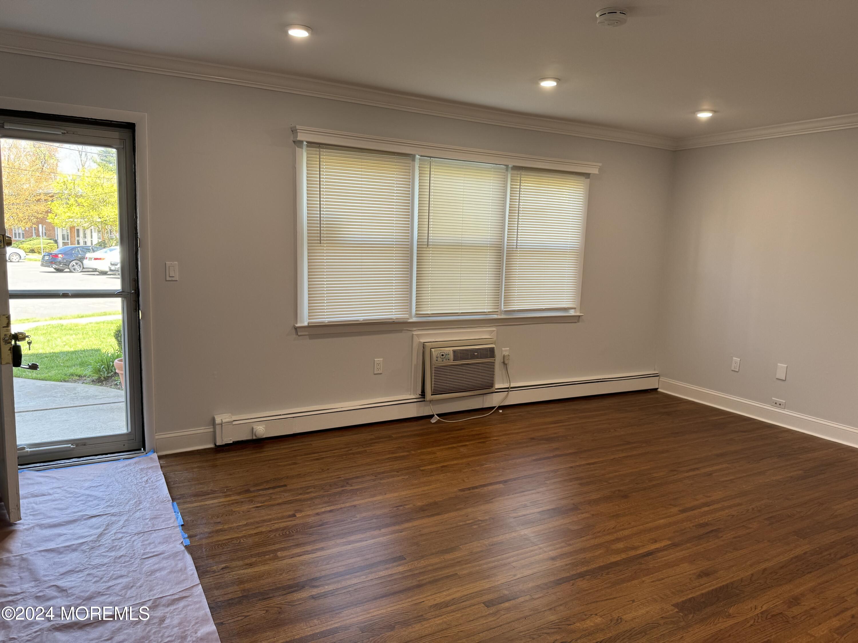an empty room with wooden floor and a window