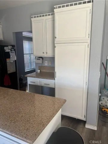 a kitchen with refrigerator cabinets and wooden floor