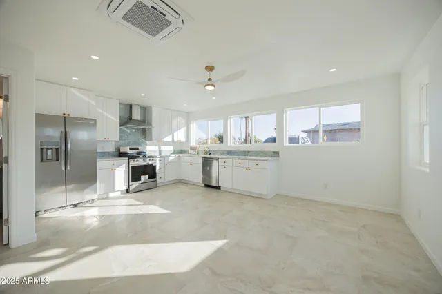 a kitchen with stainless steel appliances kitchen island granite countertop a stove a sink and a refrigerator