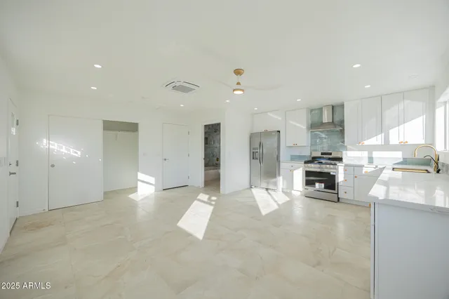 a view of kitchen with stainless steel appliances refrigerator oven and cabinets