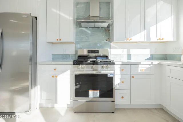 a kitchen with granite countertop a stove oven and white cabinets