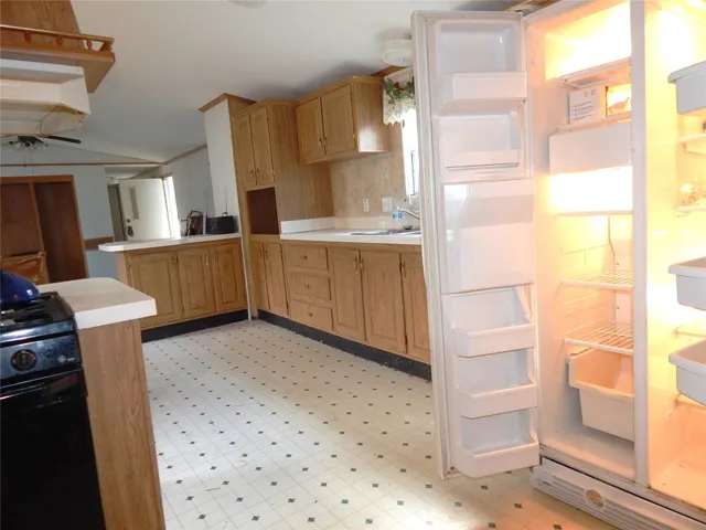 a kitchen with a refrigerator sink and cabinets
