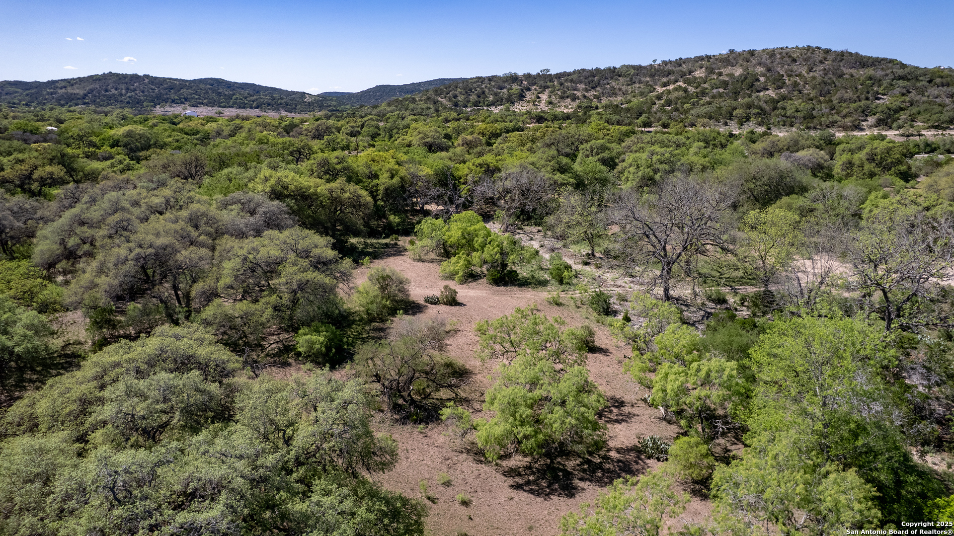 8 Camino Del Rancho Concan, TX 78838 - Photo 14 of 17 a view of a forest with a building in the background
