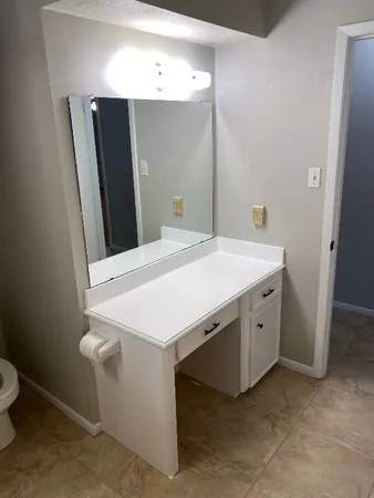 a view of a room with wooden floor and a fan