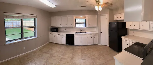 a kitchen with a refrigerator a stove a sink and cabinets