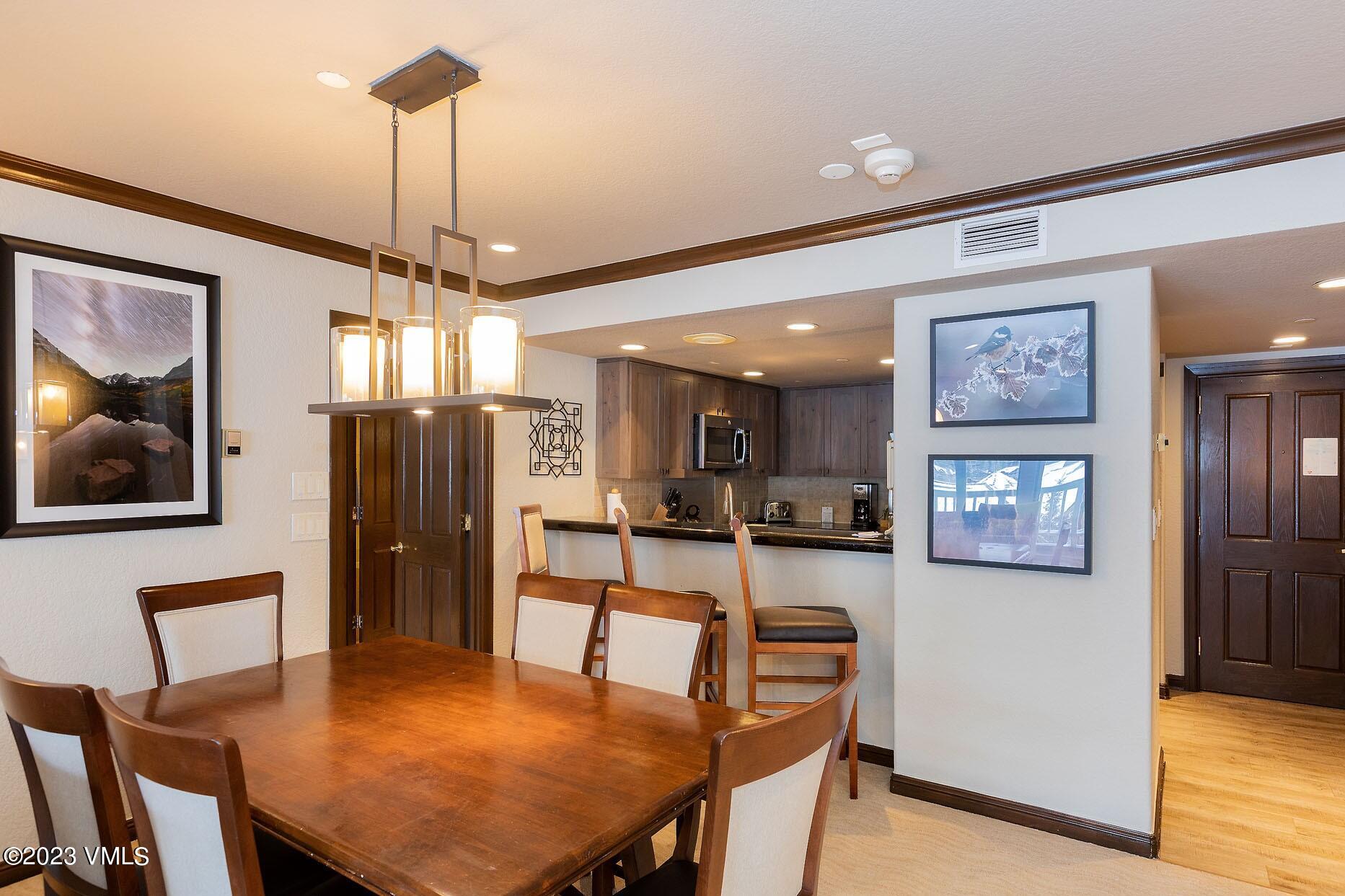 210 Offerson Road, Unit R121 WEEK 4 Beaver Creek, CO 81620 - Photo 6 of 23 a view of a dining room with furniture a chandelier and wooden floor