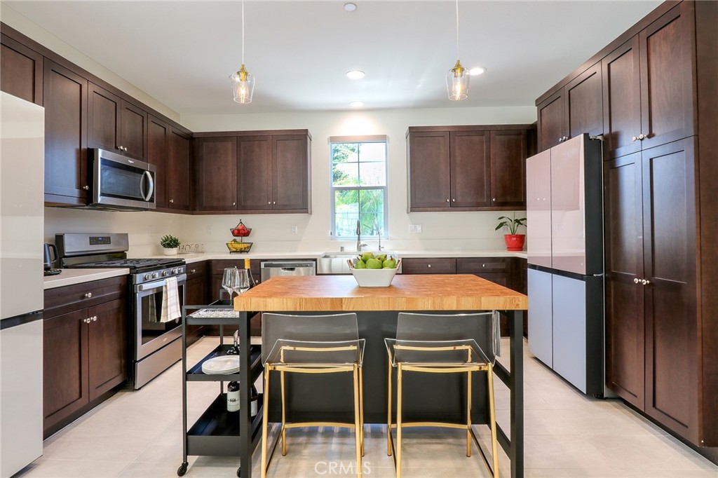 981 Rodeo Road Pomona, CA 91766 - Photo 6 of 47 a kitchen with stainless steel appliances granite countertop a stove a refrigerator a sink a stove a dining table and chairs