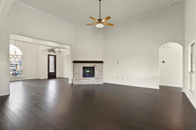 an empty room with windows and fireplace