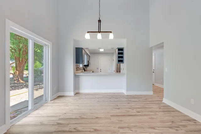 a view of a kitchen with wooden floor and a window