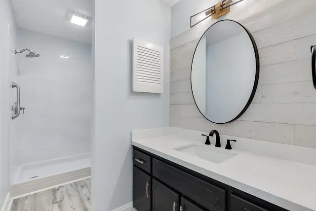 a bathroom with a sink a mirror and a shower