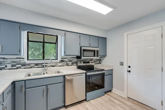 a kitchen with a sink stove and microwave