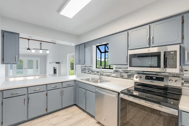a kitchen with a sink stove and microwave