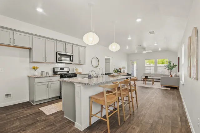 a kitchen with sink a stove cabinets and wooden floor