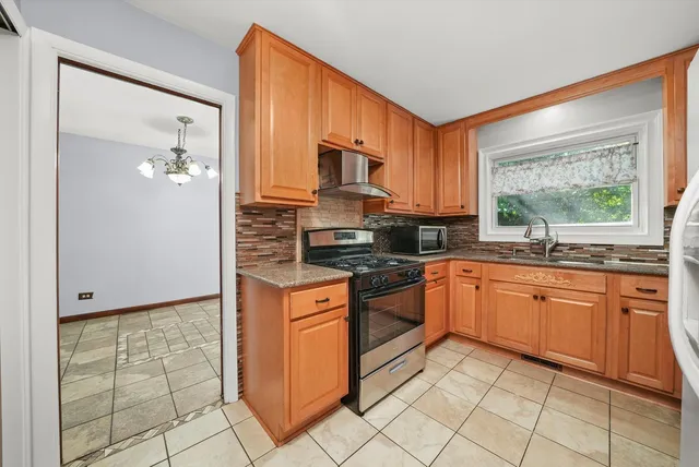 a kitchen with stainless steel appliances granite countertop a stove top oven microwave and cabinets