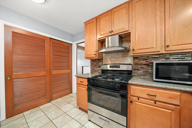 a kitchen with stainless steel appliances granite countertop a stove microwave and cabinets