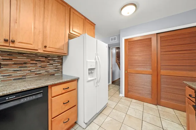 a kitchen with granite countertop a sink and a refrigerator