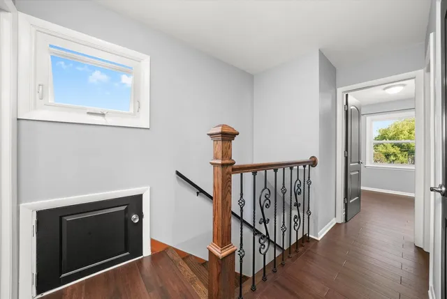 a view of a hallway with wooden floor and staircase
