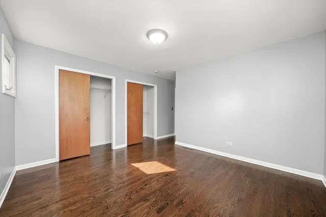 an empty room with wooden floor and natural light