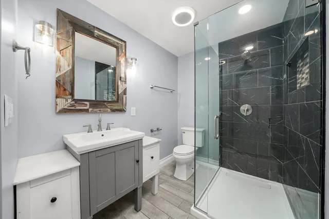 a bathroom with a sink a toilet and shower