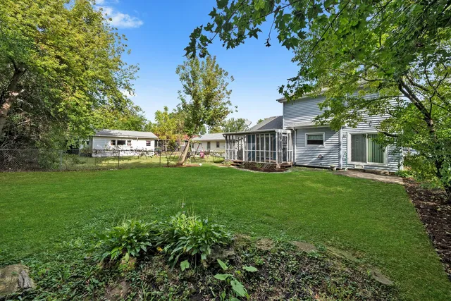 a view of a house with backyard and a sitting area