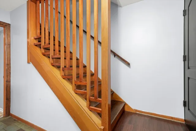 a view of staircase with wooden floor and white walls