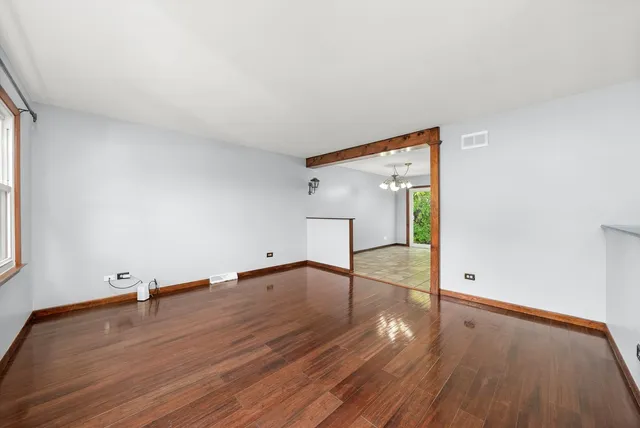 an empty room with wooden floor and mirror