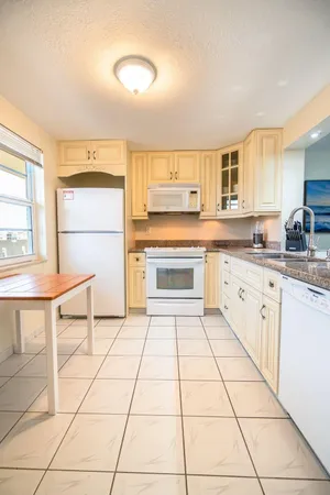 a kitchen with a sink a stove and white cabinets