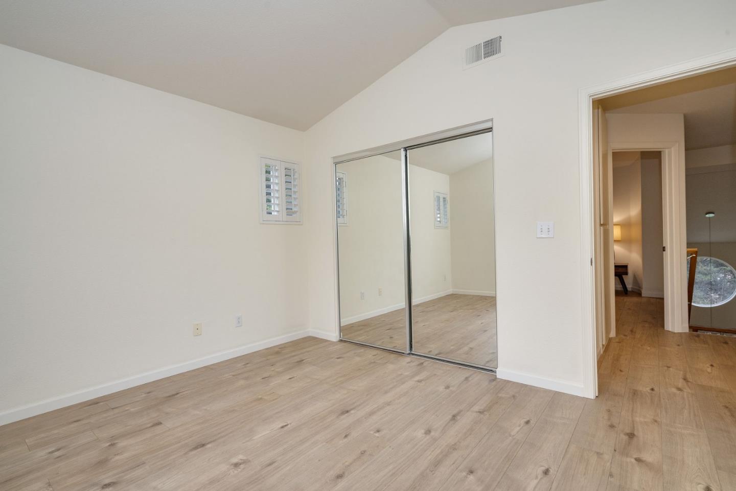 120 Patrick Way Half Moon Bay, CA 94019 - Photo 18 of 23 an empty room with wooden floor and mirror