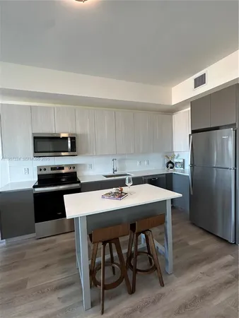 a kitchen with stainless steel appliances granite countertop a stove a sink dishwasher a refrigerator with a dining table and chairs