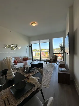 a living room with furniture fireplace and a large window
