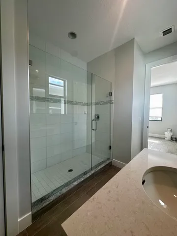 a bathroom with a granite countertop sink a toilet and shower