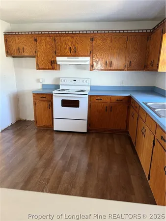 a kitchen with wooden cabinets and a stove top oven