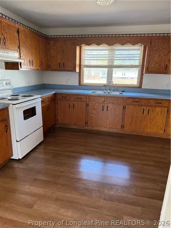 a kitchen with wooden floors and white appliances