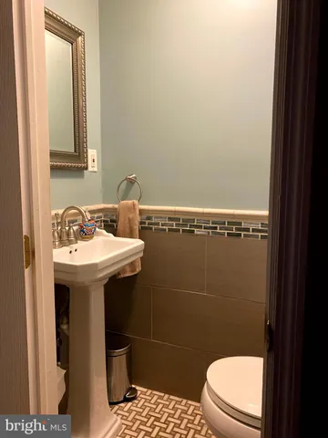 a bathroom with a sink a toilet and a mirror