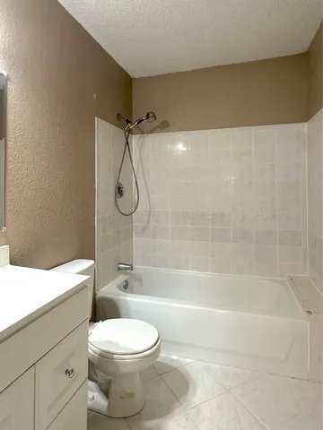 a bathroom with a toilet sink vanity and shower