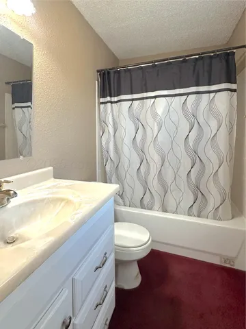 a bathroom with a granite countertop bathtub and a toilet