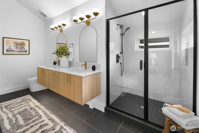 a bathroom with a double vanity sink mirror and shower
