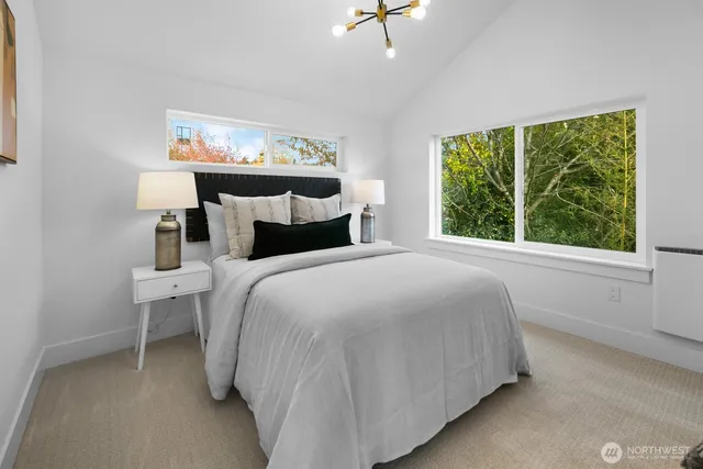 a bed sitting in a bedroom next to a window