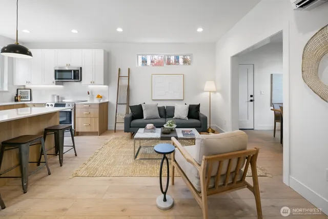 a living room with furniture a rug and kitchen view
