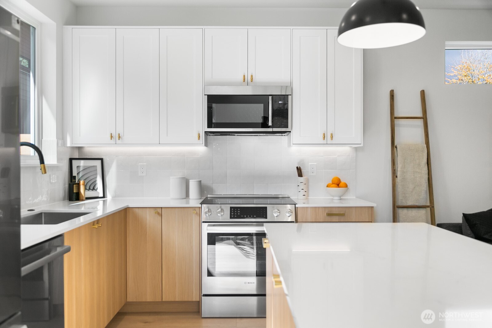 320 North 84th Street Seattle, WA 98103 - Photo 9 of 30 a kitchen with stainless steel appliances a stove a microwave and white cabinets
