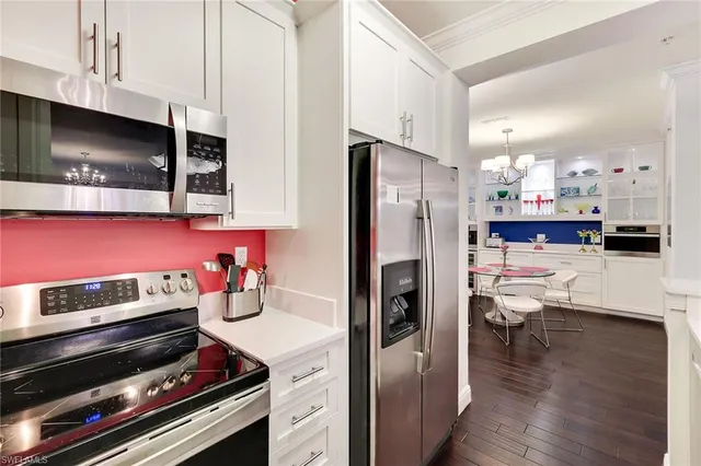 a kitchen with stainless steel appliances kitchen island granite countertop a stove a refrigerator and a microwave