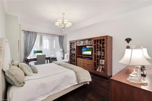 a bedroom with a bed and a flat tv screen on dresser